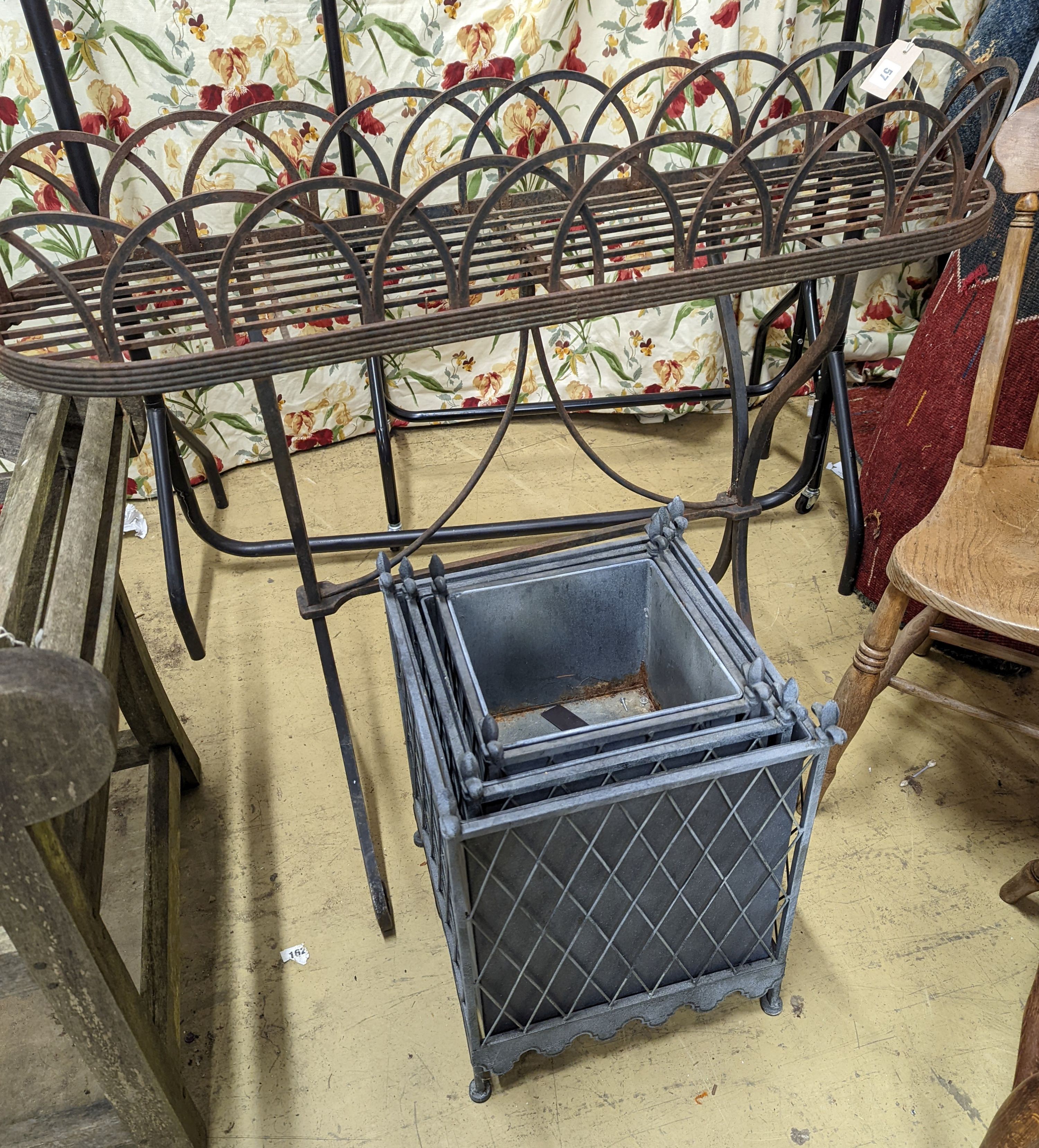 A Victorian style wrought iron pot stand, width 110cm, height 95cm, together with a graduated set of three square metal planters